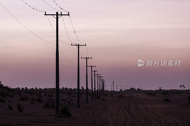 黄昏时分，在巴西北部里约热内卢Grande do Norte的Galinhos，沿着土路的电网